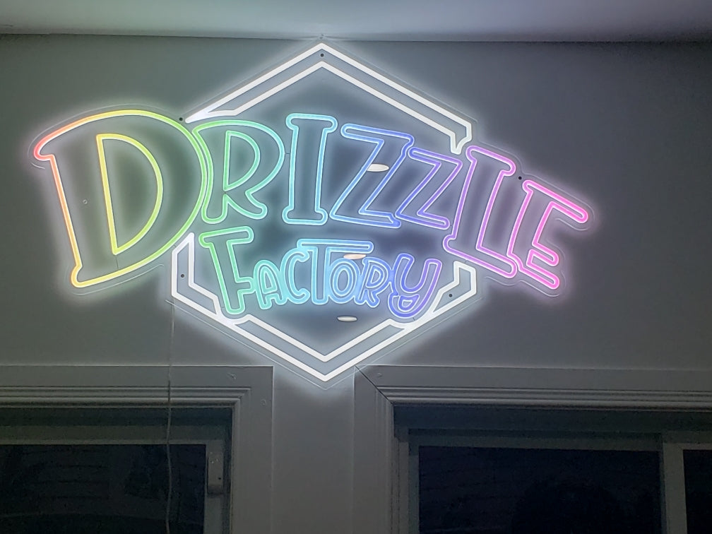 Drizzle Factory glowing sign on a wall