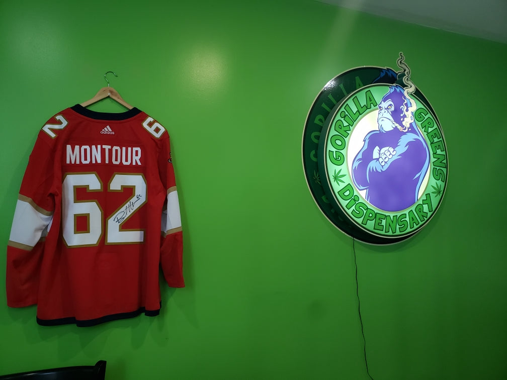 Brandon Montour Signed Jersey Next to Gorilla Greens Sign